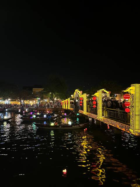       Colorful lights on boats and waterbody at night.
  