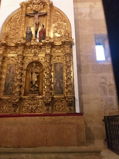       Ornate gold altarpiece inside a church.
  