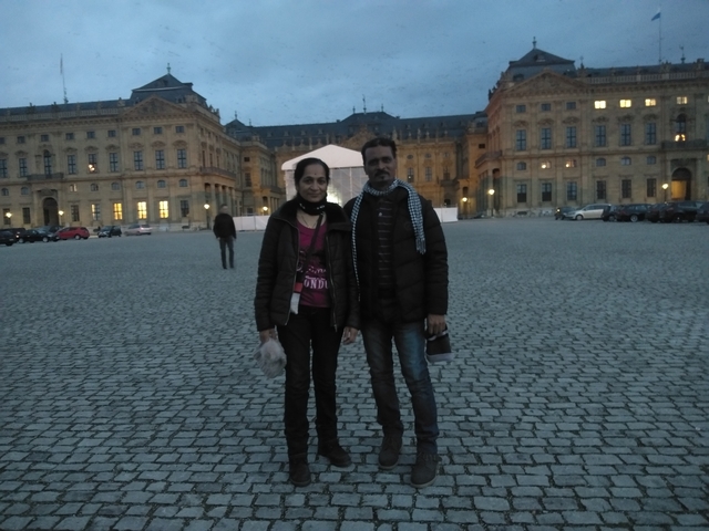       Couple posing in front of a historical building at dusk.
  