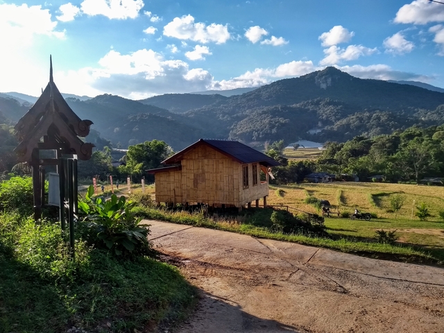 Wooden house in a mountain landscape with vibrant sky.