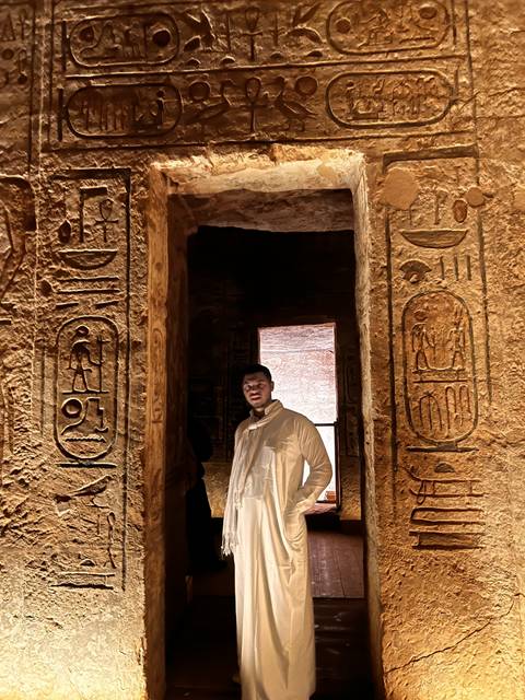       Person in a traditional attire within an ancient structure.
  
