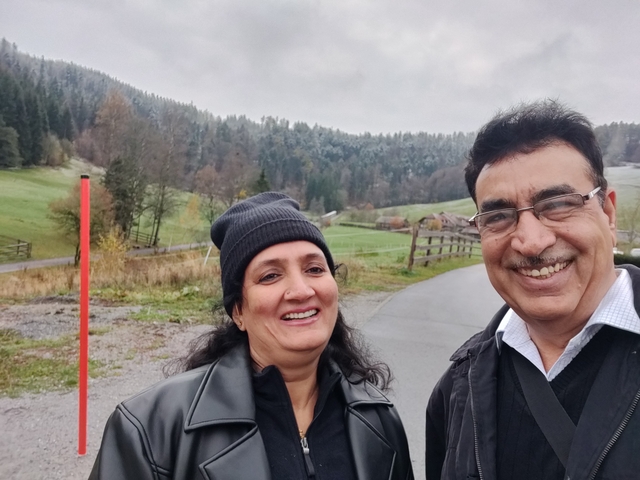 Happy couple on a rural path with green hills.