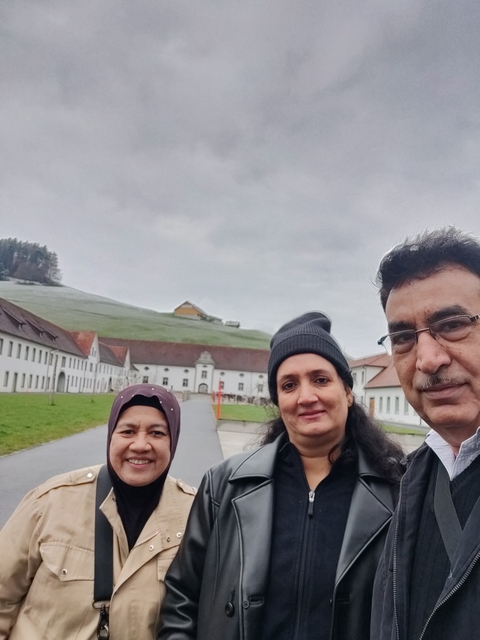 Group of people posing in front of an old building.
