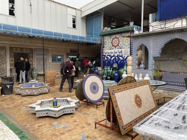       People exploring an outdoor store featuring traditional pottery.
  