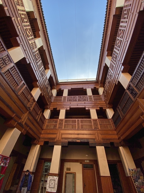       Interior view depicting elaborate wooden architecture.
  