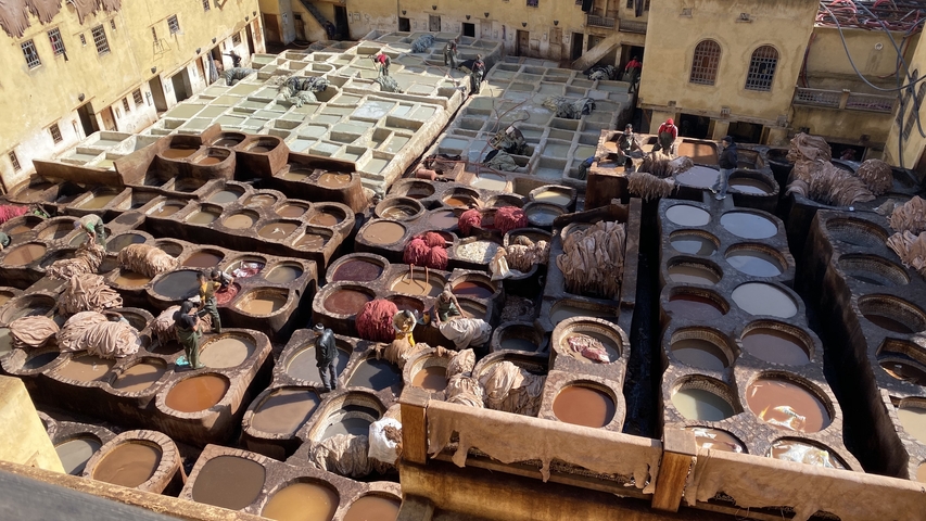       Aerial view of a traditional leather tannery with workers.
  