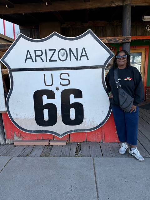 Person posing with a US Route 66 sign.