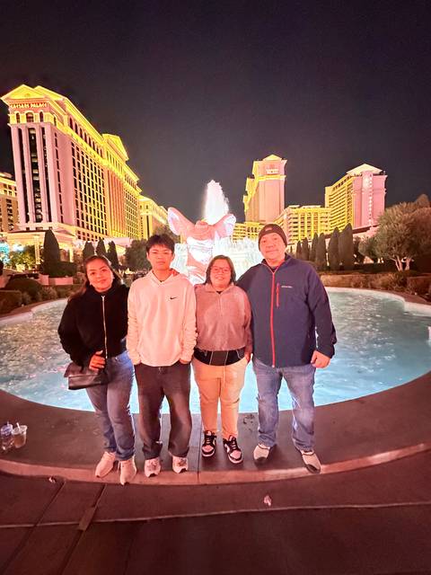 Group of people at night with fountains in the background.