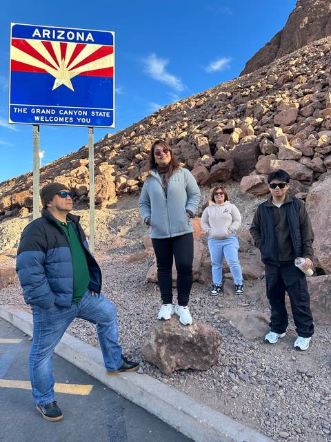 Group posing with an Arizona sign.