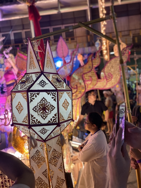 A decorative lantern and people enjoying a festival.