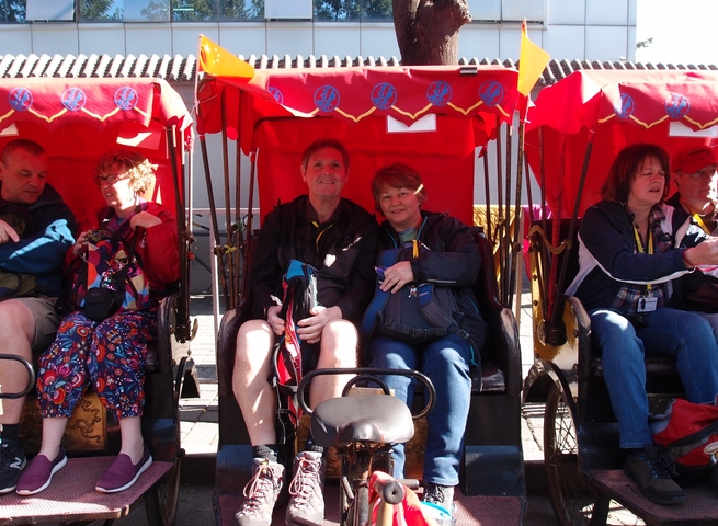 People sitting in traditional rickshaws.