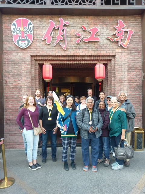 Group of tourists posing in front of a building.