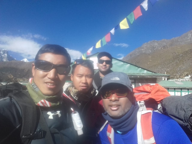       Group of four hikers with gear taking a selfie.
  