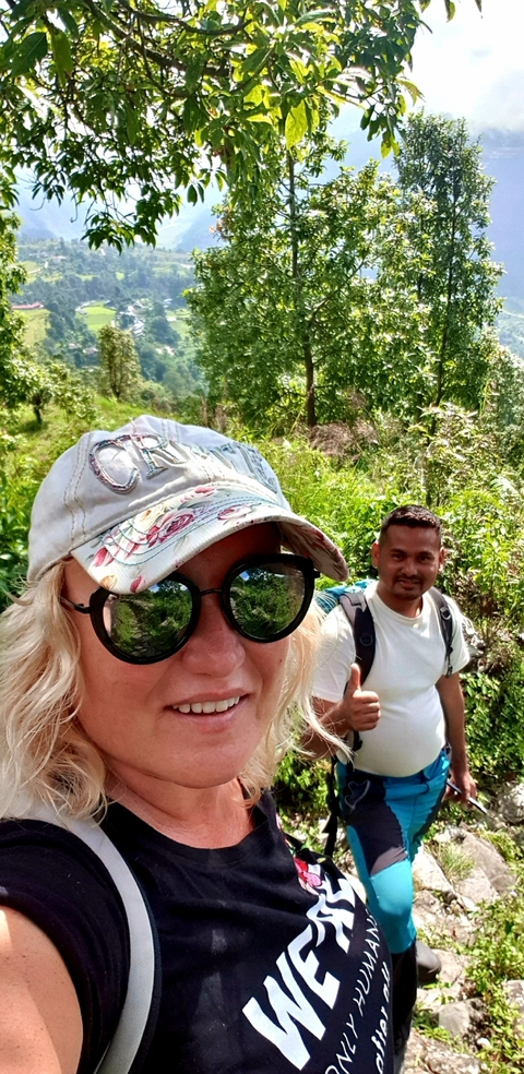 Two people taking a selfie in a lush, green area.