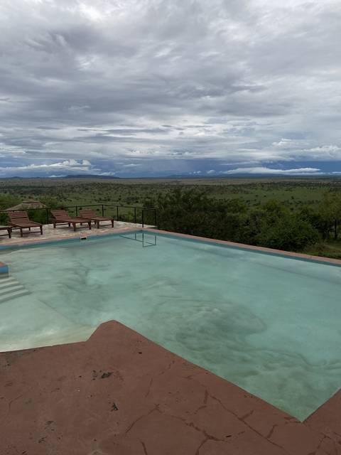       Swimming pool overlooking a vast green landscape.
  