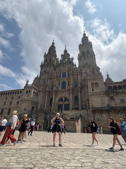 Tourists in front of a historic cathedral, likely in Santiago de Compostela.