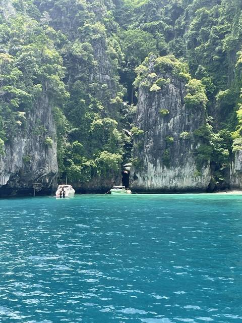 Vertical cliffs with clear blue water.