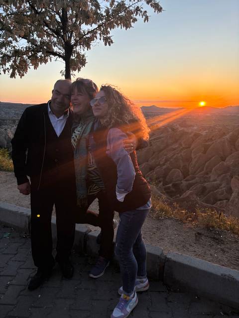       Group of people with a sunset in the background.
  