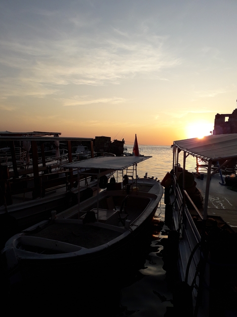       Sunset view over boats on the water.
  