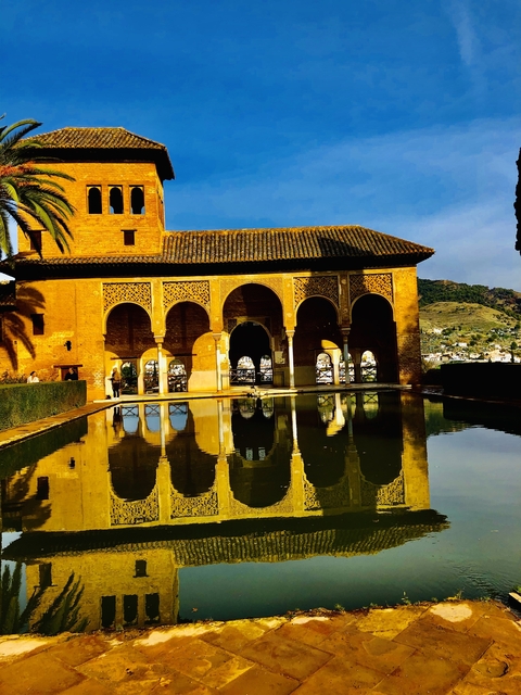 Traditional archways with reflection in a pool.