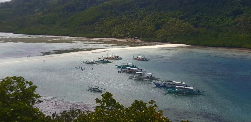       Fishing boats on a serene bay with rocky surroundings.
  