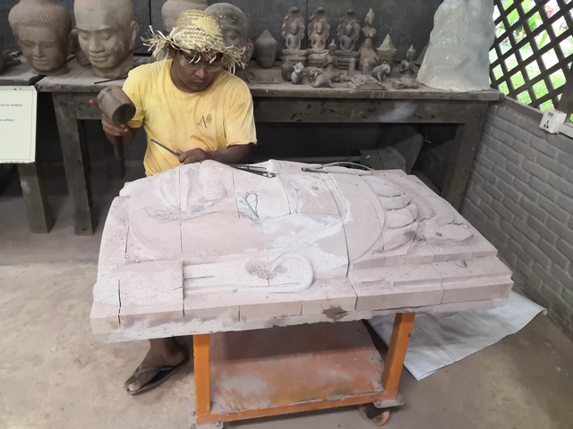 Man working on a stone carving.
