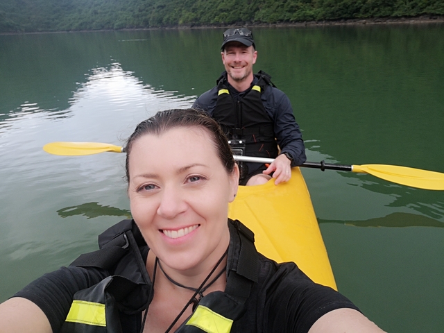 Two people in a yellow kayak taking a selfie.