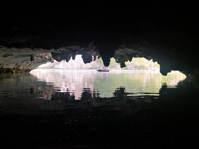       View from inside a cave looking out onto water.
  