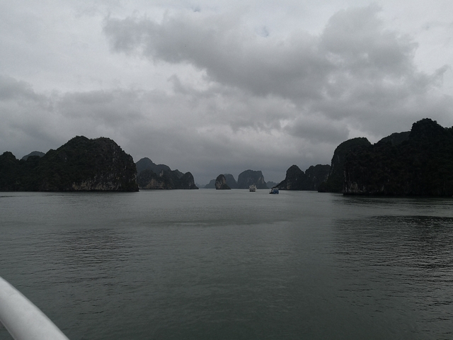 Dark cloudy view over a bay with limestone karsts.