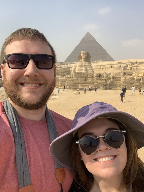       Couple posing in front of the Sphinx and pyramids.
  