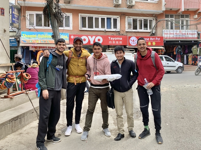 Group of friends posing on a bustling street.