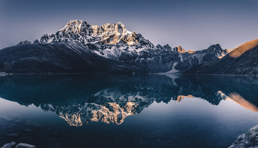       Majestic snow-capped mountains reflecting perfectly on a calm lake.
  