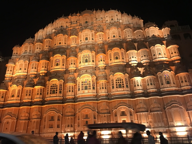Hawa Mahal illuminated at night with intricate architecture.