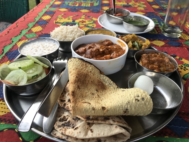 Traditional Indian meal served in metal dishes on a table.