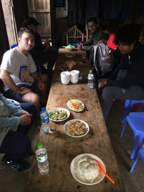       Group meal indoors with assorted dishes on a wooden table.
  
