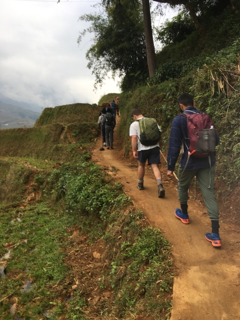       Group of hikers walking along a dirt path through fields.
  