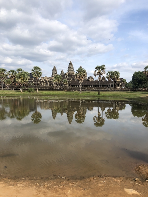       The Angkor Wat temple complex with its reflection in a pond.
  