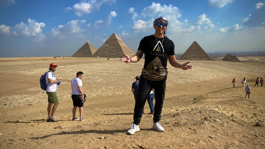 Person standing in front of the pyramids.