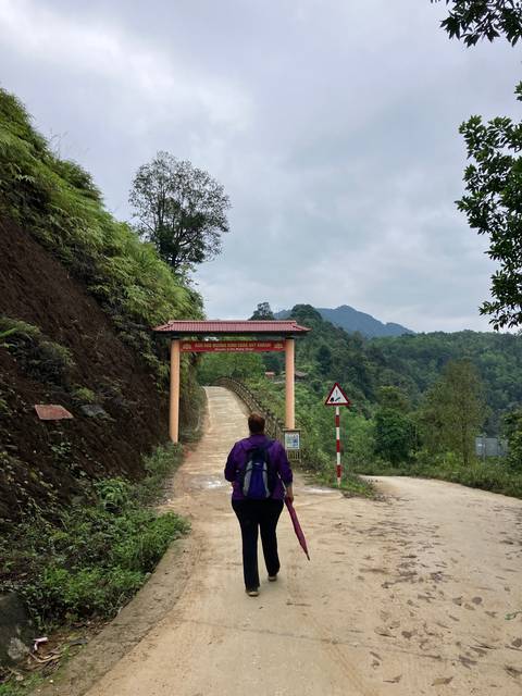       Person walking on a rural path surrounded by mountains.
  