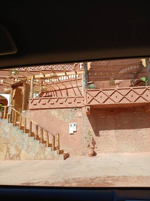      Exterior view of a traditional building with reddish walls.
  