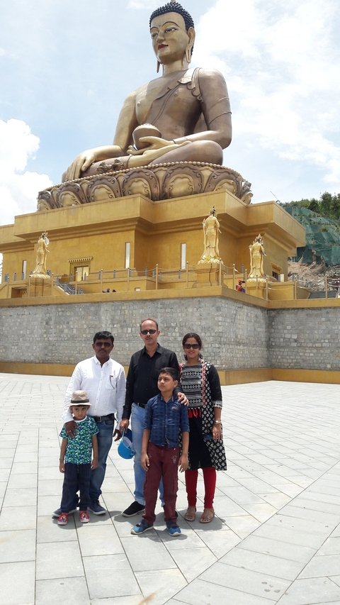       Family posing in front of a golden building.
  