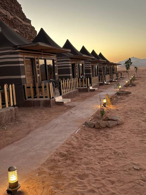 Desert camp with traditional tents at sunset.