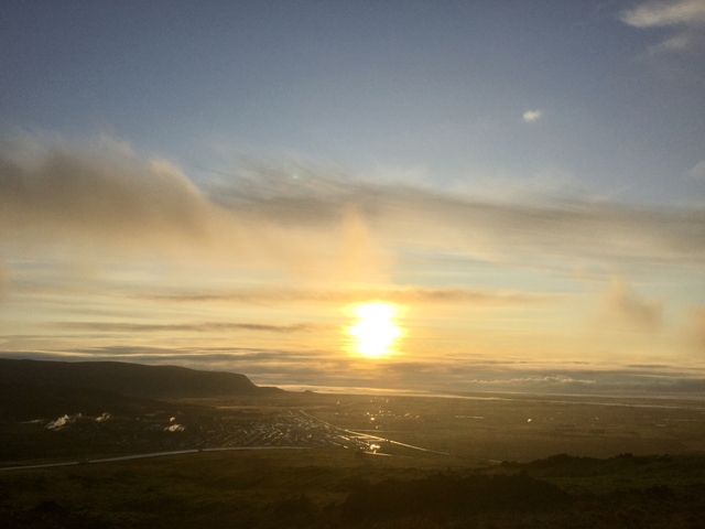 Sunset over a vast landscape with clouds.