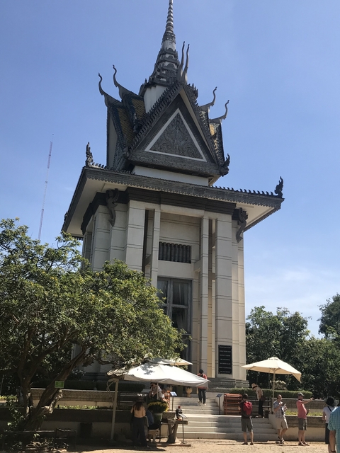 A Khmer-style stupa tower against a clear blue sky.