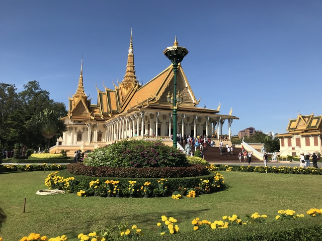 A large ornate temple with visitors outside.