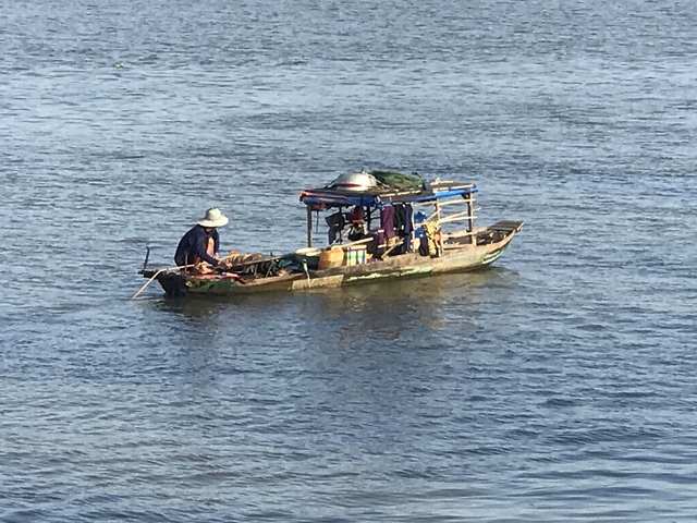       A person on a small boat in a large river.
  