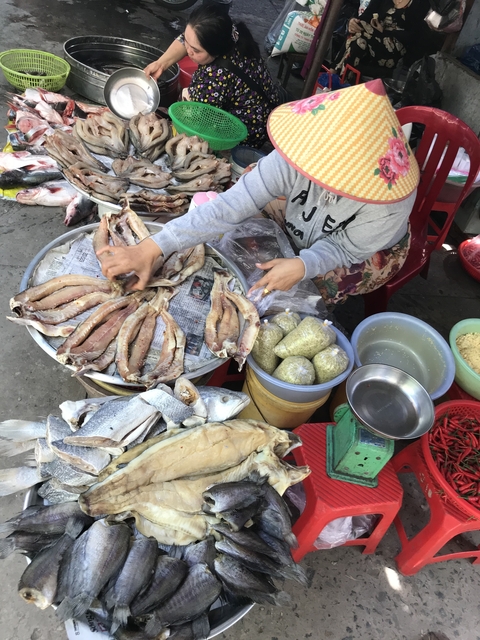 Market scene with fish and other food items displayed.