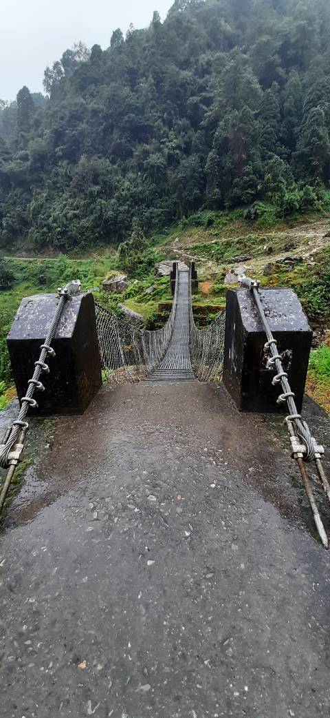 A suspension bridge over a lush valley.