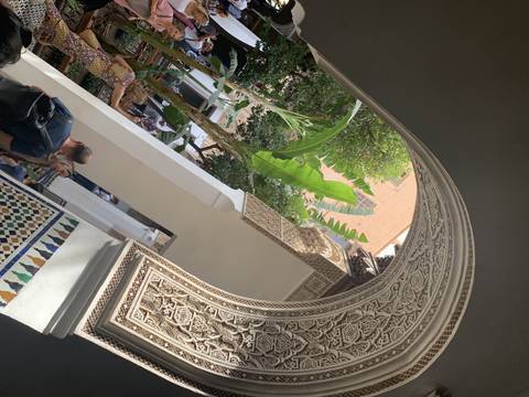       Rotated image of people in a courtyard with ornate architecture.
  