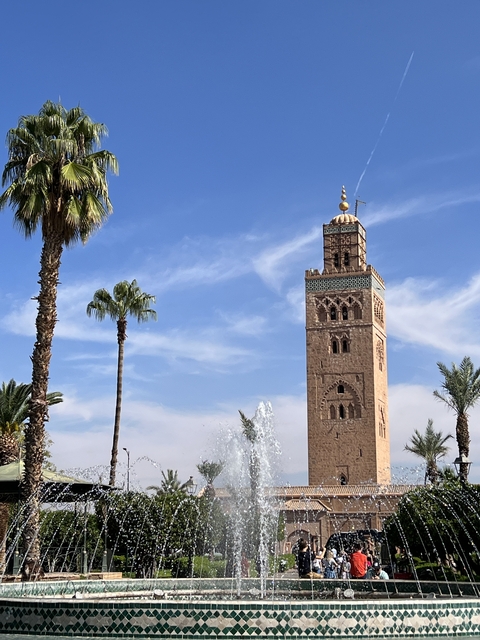       A tower structure with palm trees under a clear sky.
  